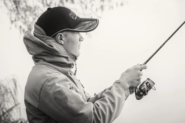 Rybář s rotací na břehu řeky. — Stock fotografie
