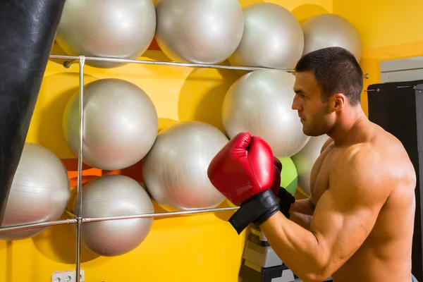 М'язистий чоловік в боксерських рукавичках в спортзалі — стокове фото