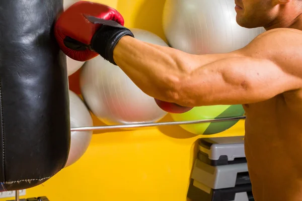 Muskelmand i boksehandsker i fitnesscenter - Stock-foto