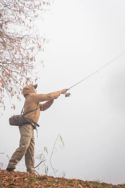 Fiskare med spinning på flodstranden — Stockfoto