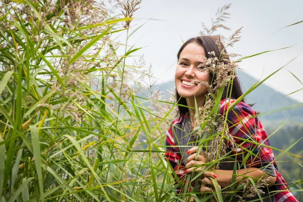 Jong meisje permanent in hoog gras — Stockfoto