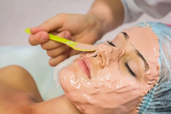 Jovem mulher recebendo máscara facial — Fotografia de Stock