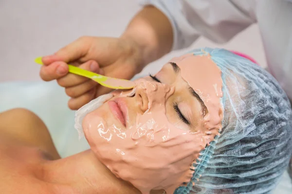 Ung kvinna mottagande ansiktsmask — Stockfoto
