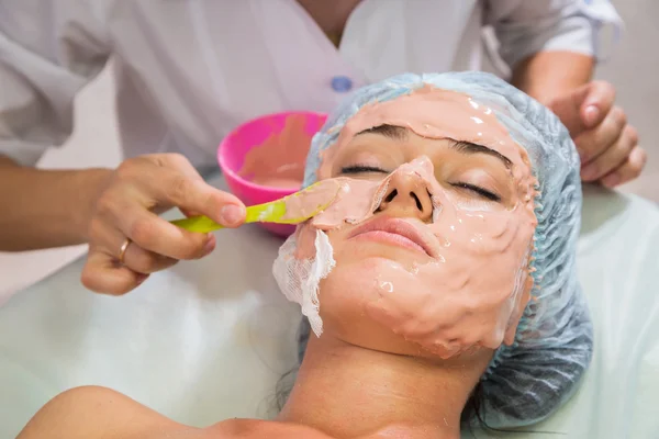 Jeune femme recevant un masque facial — Photo