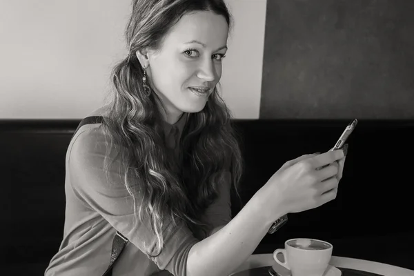 Meisje met kopje cappuccino in café. — Stockfoto