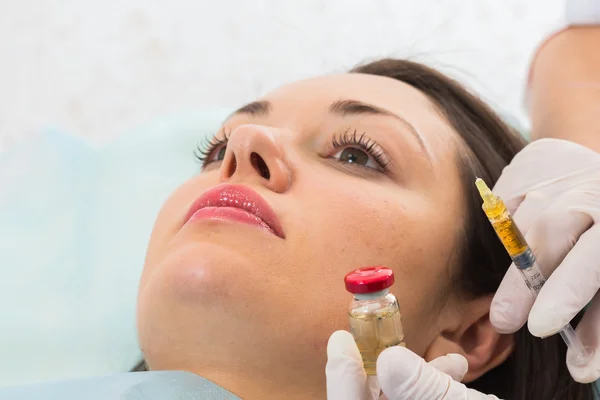 Kosmetolog gör injektion i patientens ansikte — Stockfoto