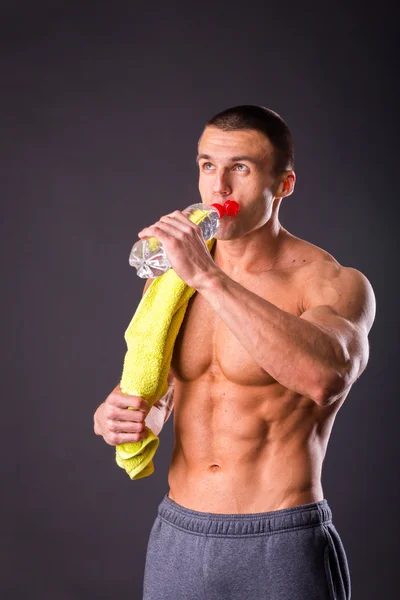 Athletic man holding a bottle of water — Stock Photo, Image