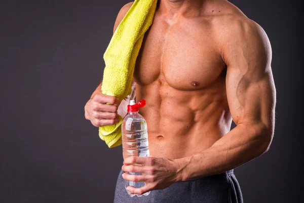 Atletisk man håller en flaska vatten — Stockfoto