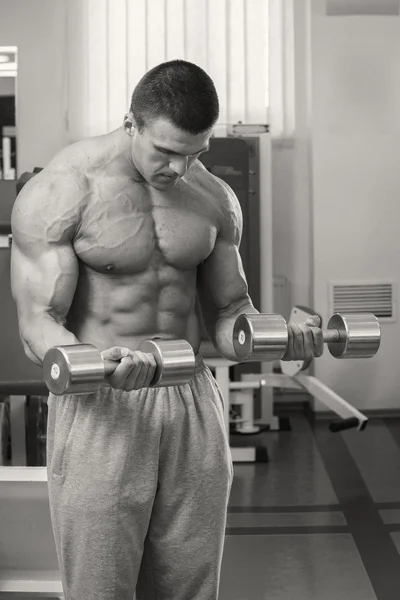 Hombre musculoso haciendo ejercicio con pesas — Foto de Stock