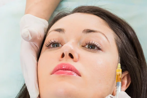 Beautician makes injection into the patient's face — Stock Photo, Image