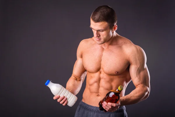 Hombre sosteniendo una cerveza y leche —  Fotos de Stock