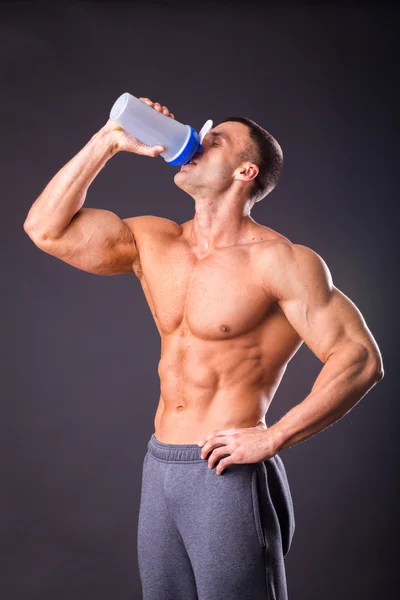 Bodybuilder hält einen Shaker für Getränke — Stockfoto