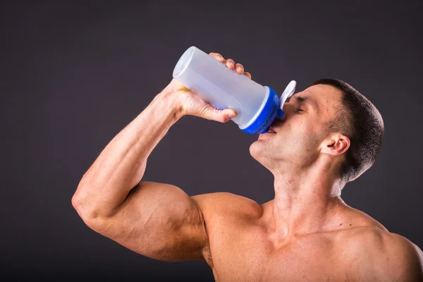 Bodybuilder holding a shaker for drinks — Stock Photo, Image