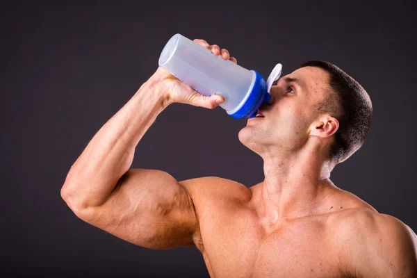 Bodybuilder holding a shaker for drinks — Stock Photo, Image