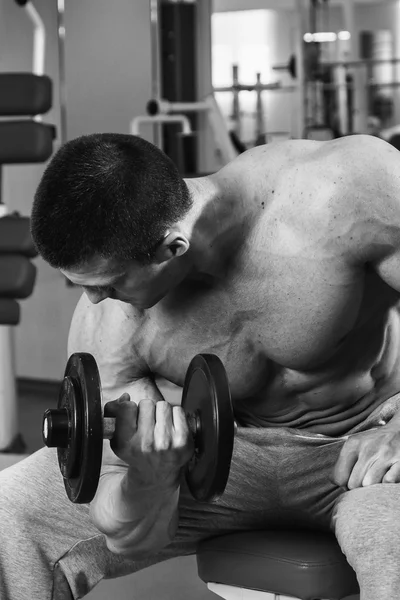 Homem musculoso trabalhando com halteres — Fotografia de Stock