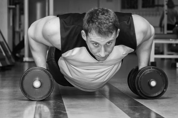 Hombre haciendo ejercicio con pesadas mancuernas — Foto de Stock