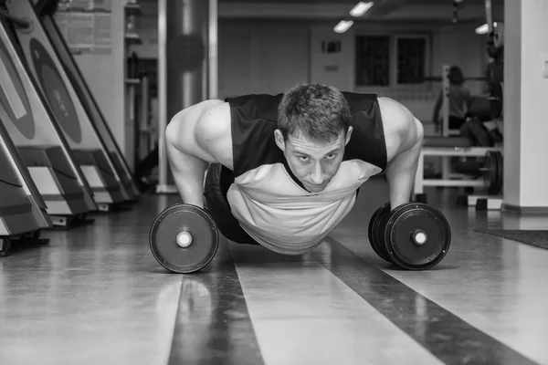 Hombre haciendo ejercicio con pesadas mancuernas — Foto de Stock