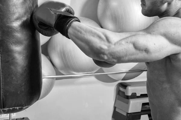 Мускулистый человек в боксёрских перчатках в спортзале — стоковое фото