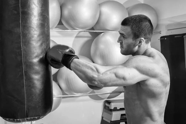Hombre musculoso en guantes de boxeo en gimnasio — Foto de Stock