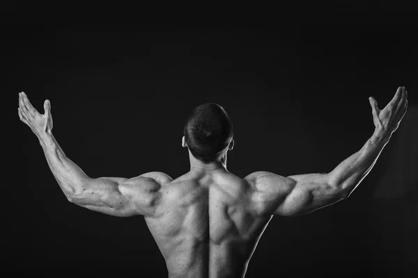 Fisiculturista mostra seus músculos das costas . — Fotografia de Stock
