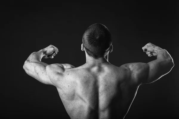 Bodybuilder shows his back muscles. — Stock Photo, Image