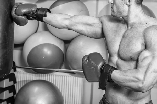 Man slå en slagsäck i gym — Stockfoto