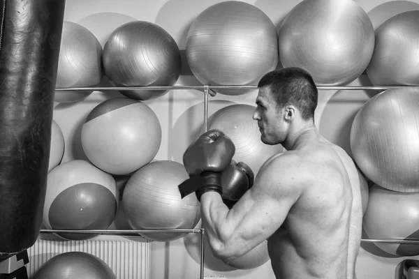 Hombre golpeó un saco de boxeo en el gimnasio —  Fotos de Stock