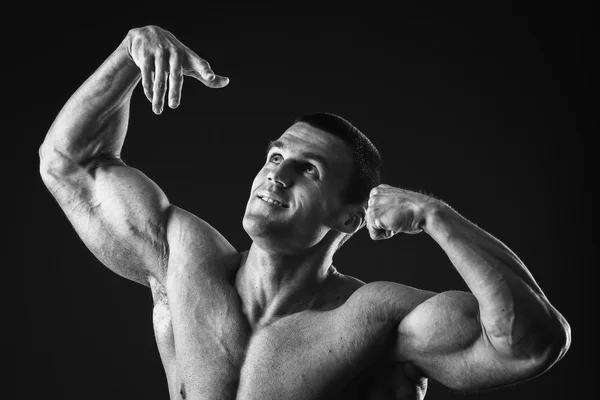 Gespierde bodybuilder toont zijn spieren. — Stockfoto