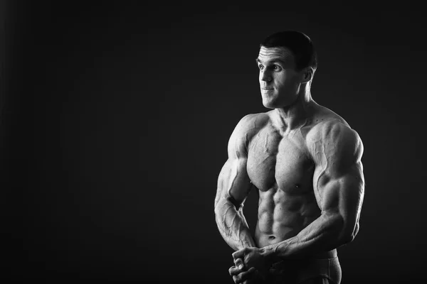 Muscular bodybuilder shows his muscles. — Stock Photo, Image