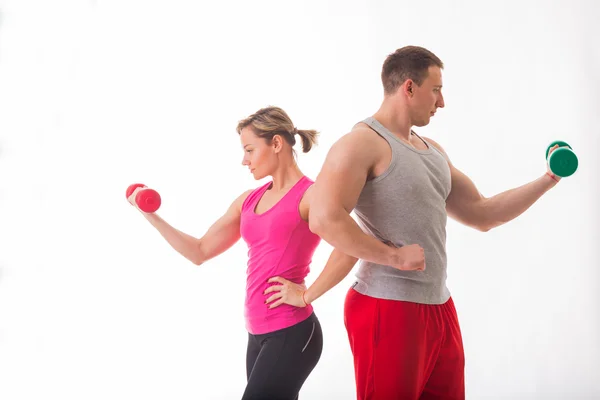 Athletic couple holding dumbbells — Stock Photo, Image