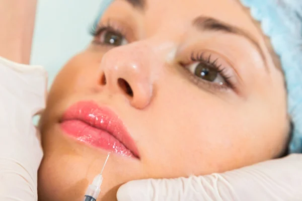 Beautician makes injection into the patient's face — Stock Photo, Image