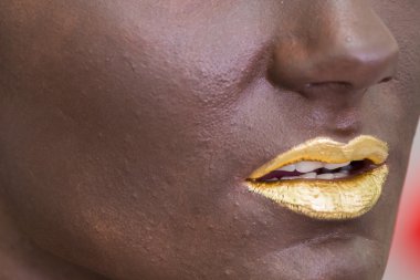 Koyu makyaj yüzündeki altın dudaklar