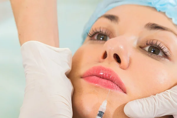 Beautician makes injection into the patient's face — Stock Photo, Image