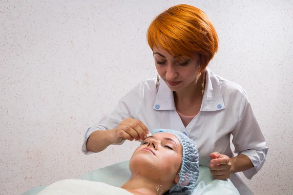 Schoonheidsspecialiste toepassing cosmetische crème — Stockfoto