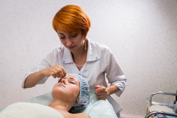 Beautician applying cosmetic cream — Stock Photo, Image