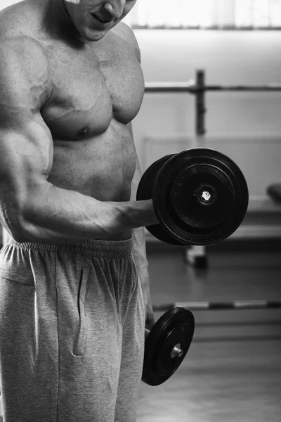 Homem musculoso trabalhando com halteres — Fotografia de Stock