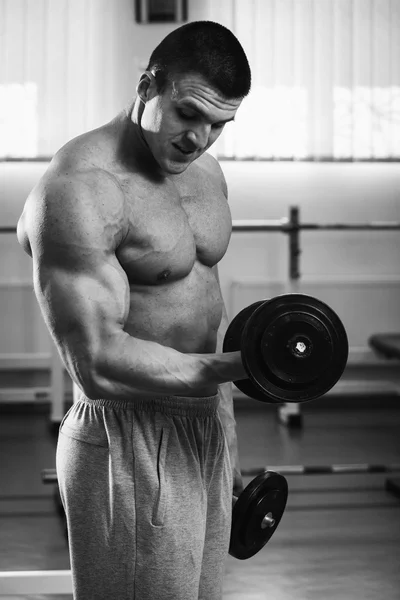 Homem musculoso trabalhando com halteres — Fotografia de Stock