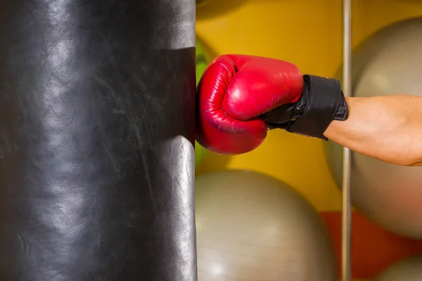 Boxing glove hit a punching bag — Stock Photo, Image