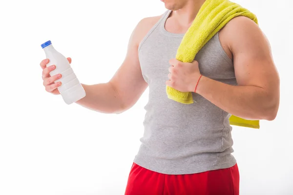 Athletic man holding a bottle of milk — Stock Photo, Image