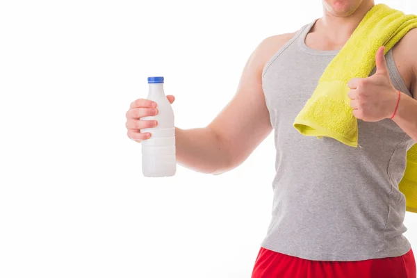 Atletický muž držící láhev mléka — Stock fotografie