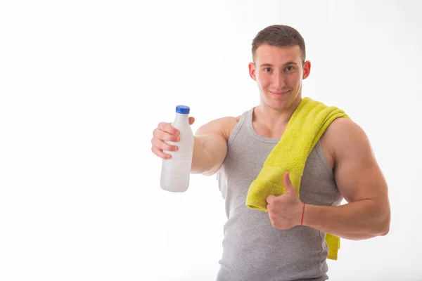 Athletic man holding a bottle of milk — Stock Photo, Image