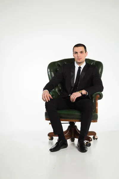 Homem de negócios sentado na cadeira de couro — Fotografia de Stock
