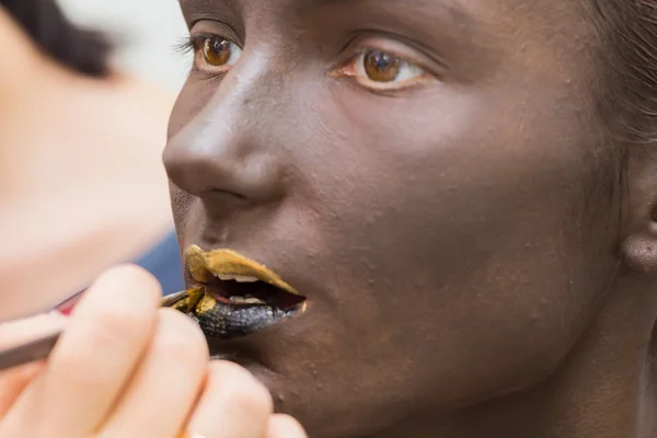 Golden lips on dark make-up face — Stock Photo, Image