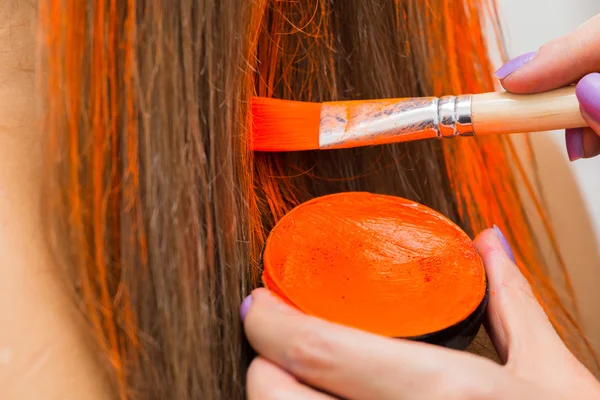 Maquillaje artista pinta el cabello en naranja —  Fotos de Stock