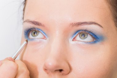 Makeup artist paints the eyebrows model.