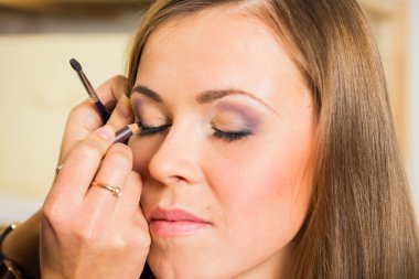 Modeli için makyaj yapıyor makyaj sanatçısı