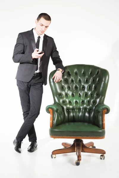 Businessman near a green leather chair — Stock Photo, Image