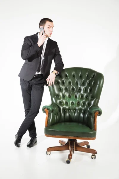 Businessman near a green leather chair — Stock Photo, Image