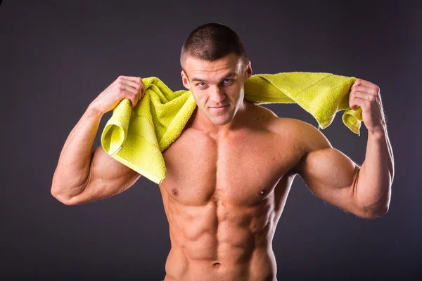 Homem de fitness segurando uma toalha amarela — Fotografia de Stock