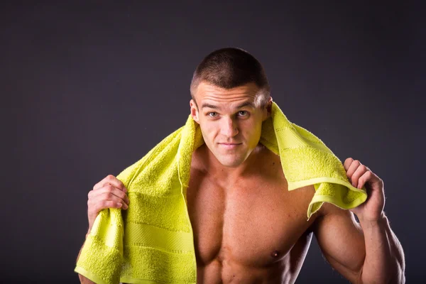 Hombre de fitness sosteniendo una toalla amarilla —  Fotos de Stock